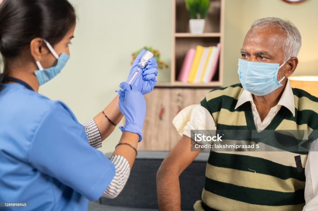Clinician preparing a vaccine for an adult patient in a supervised care setting